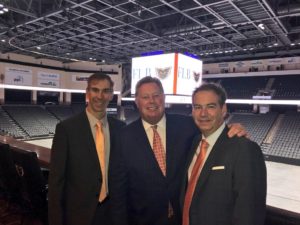 Photo of Jim Brooks, Joe Fitzpatrick and Rob Brooks at the PPL Center in Allentown, PA with the hockey arena behind them. 