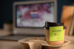 Closeup of Welcome Note on Takeaway Coffee Cup in Office Desk. Message from a Colleague or Boss