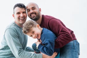 Gay fathers and son having fun together outdoors