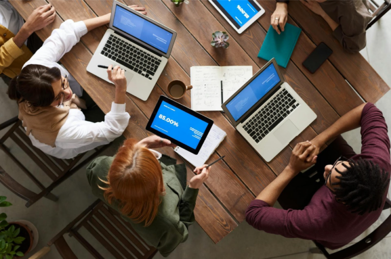 group of people using macbooks while discussing